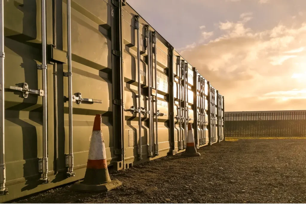 Row of portable storage units in green under the golden light of sunset with reflective metallic surfaces