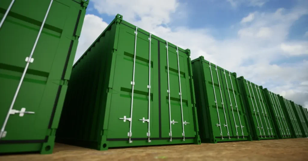 Large storage containers in green, arranged in rows under a bright sky, ideal for industrial or business needs